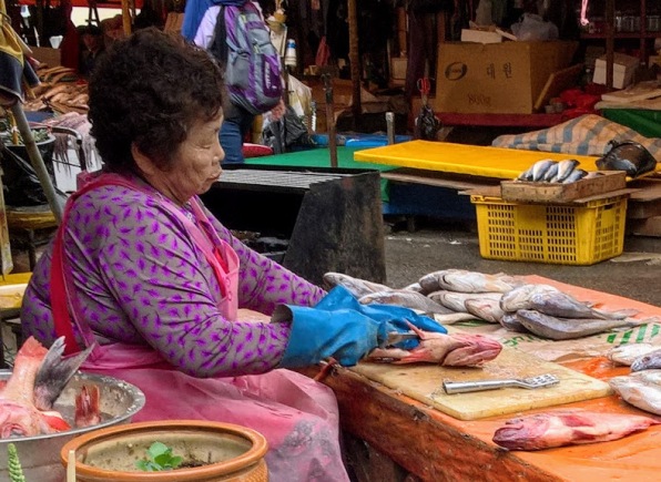 A woman filleting fish at Jagalchi Market, Busan, South Korea - perhaps the largest fish market in the world.